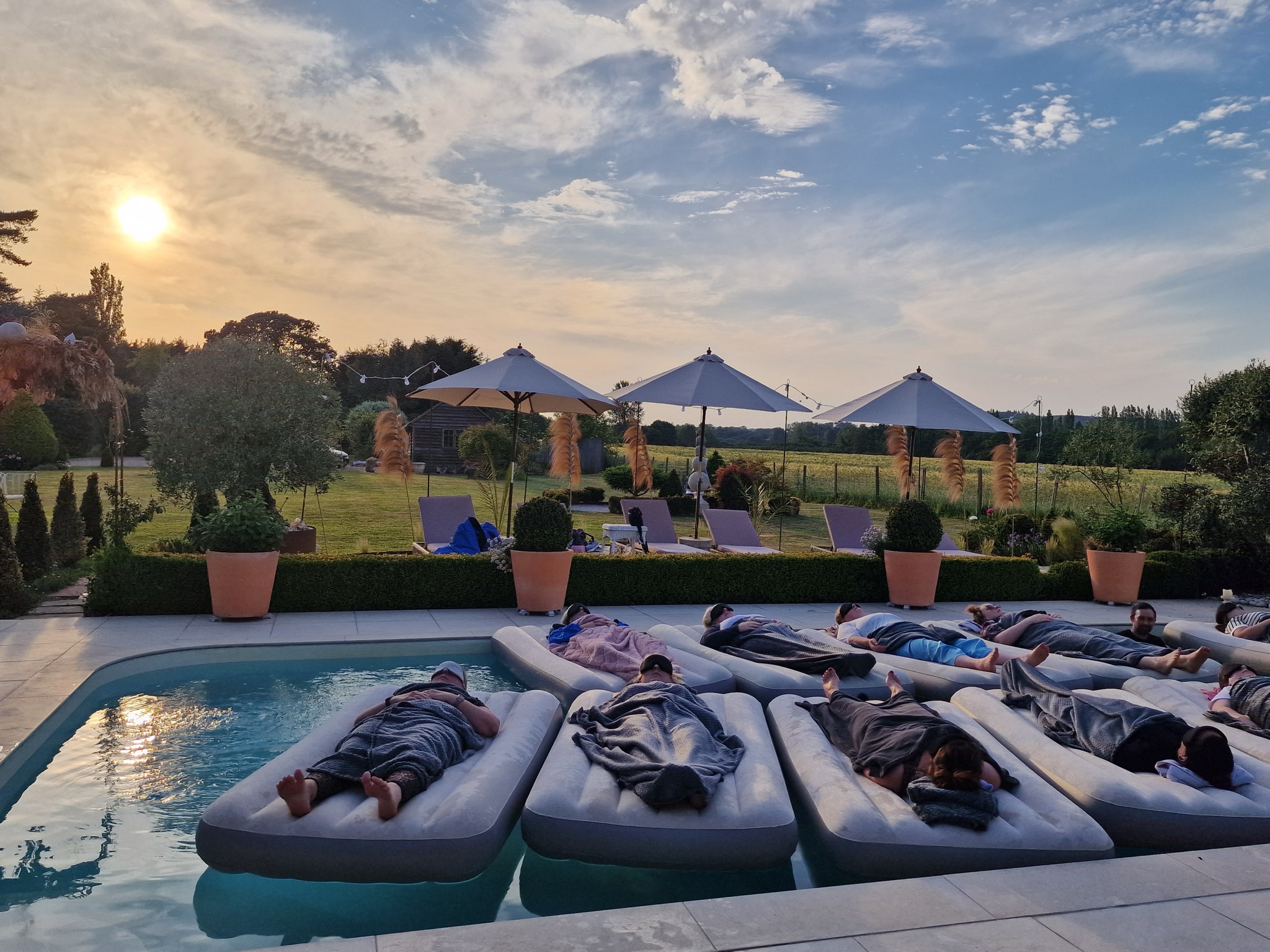 Sunset sound bath at Red House Venue with guests floating on the pool